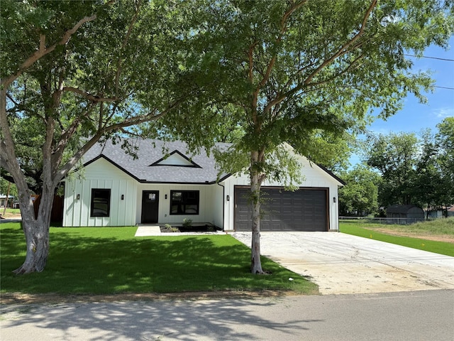 401 Pecan St, Grandview, TX 76050 - view of front facade featuring board and batten siding, a garage, concrete driveway, roof with shingles, and a front yard