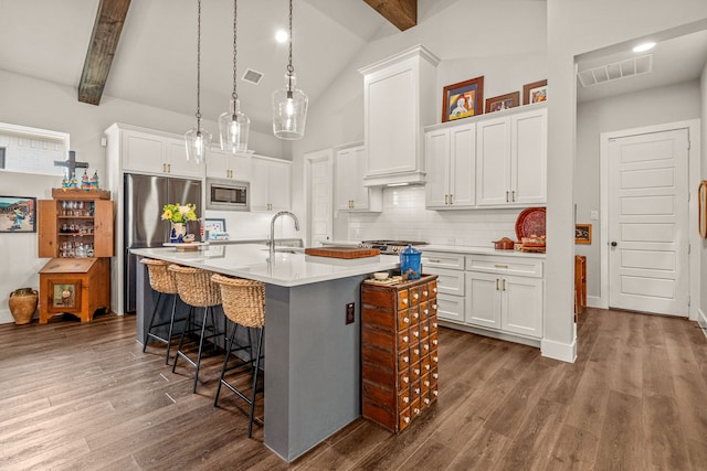 14344 Walsh Ave, Fort Worth, TX 76008 - kitchen with stainless steel appliances, a breakfast bar area, dark wood-style flooring, beamed ceiling, and backsplash