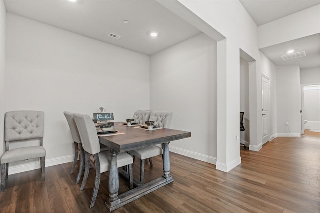dining area with baseboards, wood finished floors, and recessed lighting