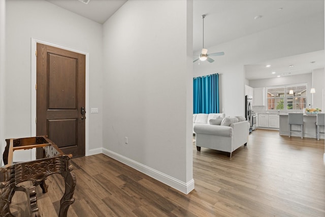hall featuring light wood finished floors and baseboards