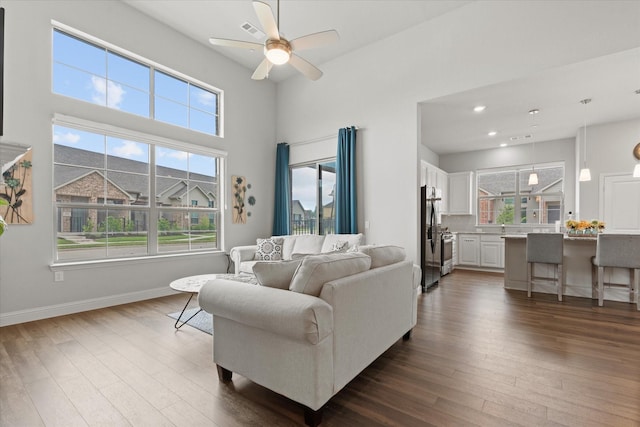 living area with dark wood-style flooring, ceiling fan, recessed lighting, and baseboards