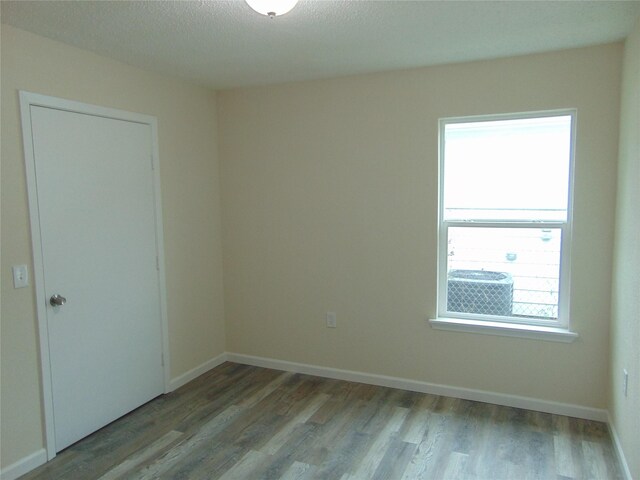 7928 Hull Ave, Dallas, TX 75216 - spare room with wood finished floors, baseboards, and a textured ceiling