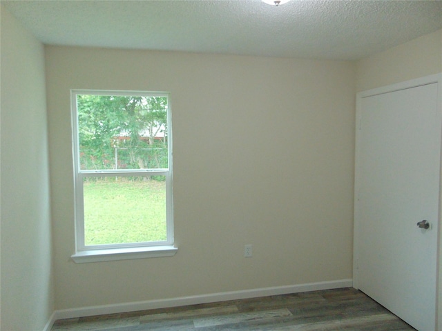 7928 Hull Ave, Dallas, TX 75216 - spare room featuring plenty of natural light, wood finished floors, a textured ceiling, and baseboards