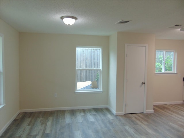 7928 Hull Ave, Dallas, TX 75216 - empty room with wood finished floors, baseboards, and a textured ceiling