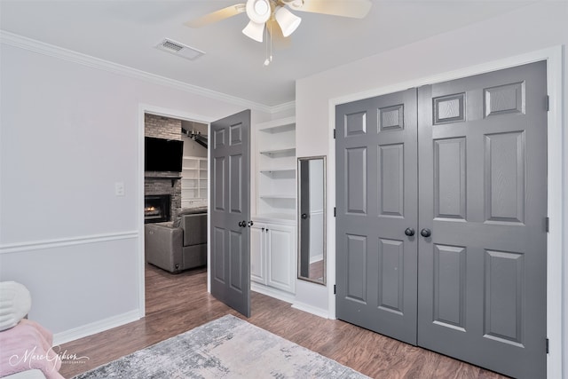 102 Pinehurst Pl, Benton, LA 71006 - bedroom with a stone fireplace, wood finished floors, crown molding, a closet, and baseboards