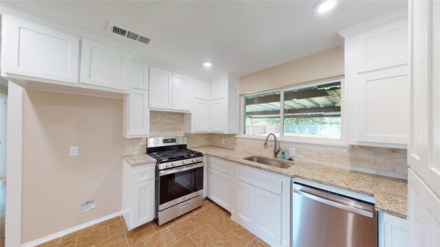 3201 Lakeland St, Fort Worth, TX 76111 - kitchen featuring appliances with stainless steel finishes, a sink, backsplash, white cabinetry, and recessed lighting