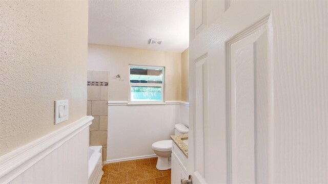 3201 Lakeland St, Fort Worth, TX 76111 - bathroom with toilet, a textured wall, vanity, and shower / bathtub combination