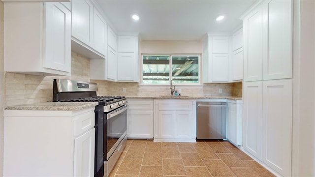 3201 Lakeland St, Fort Worth, TX 76111 - kitchen with appliances with stainless steel finishes, a sink, white cabinets, decorative backsplash, and recessed lighting