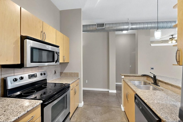 201 W Lancaster Ave Unit 218, Fort Worth, TX 76102 - kitchen featuring appliances with stainless steel finishes, a sink, light brown cabinetry, baseboards, and finished concrete floors