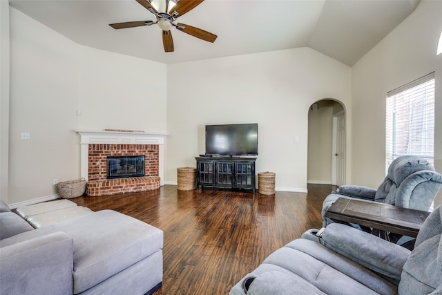living area featuring a ceiling fan, arched walkways, wood finished floors, lofted ceiling, and baseboards