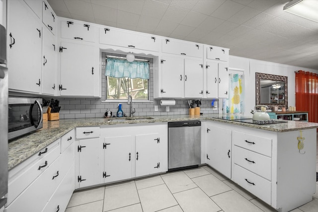 4900 Ira St, Haltom City, TX 76117 - kitchen with a sink, stainless steel appliances, tasteful backsplash, a peninsula, and white cabinets