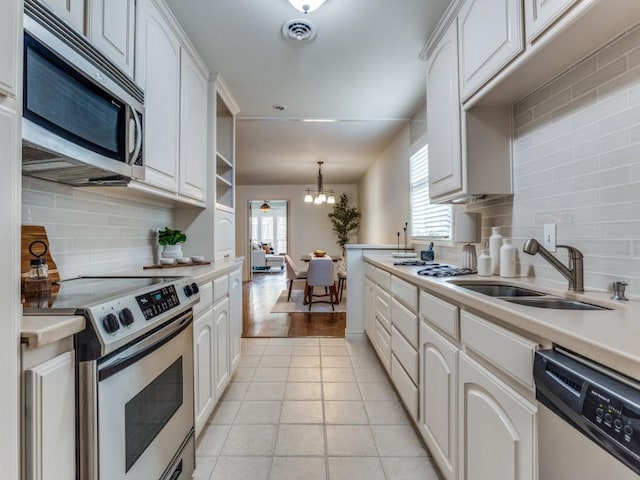 827 Sherbrook Dr, Richardson, TX 75080 - kitchen featuring appliances with stainless steel finishes, tasteful backsplash, light countertops, a sink, and white cabinetry