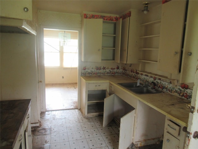 3108 Woodford St, Shreveport, LA 71108 - kitchen featuring open shelves, a sink, light floors, and a chandelier