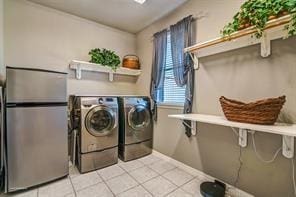 930 Lakeridge Dr, Lavon, TX 75166 - laundry room featuring washing machine and dryer, light tile patterned floors, and baseboards