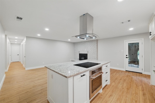 742 Chalk Hill Ln, Desoto, TX 75115 - kitchen with oven, exhaust hood, black electric stovetop, light wood-style floors, and white cabinetry