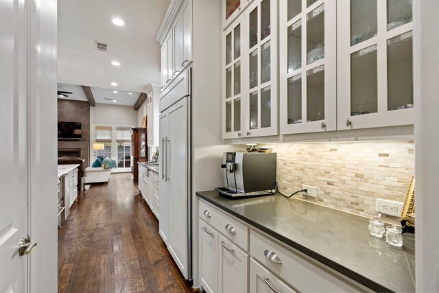 7315 Danashire Ave, Dallas, TX 75231 - kitchen featuring dark wood finished floors, decorative backsplash, glass insert cabinets, recessed lighting, and open floor plan