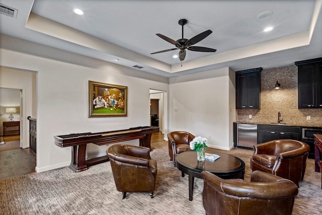 7315 Danashire Ave, Dallas, TX 75231 - interior space featuring a tray ceiling, baseboards, a ceiling fan, bar with sink, and recessed lighting