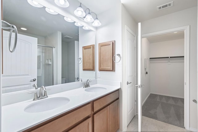 7789 Gulf Breeze Ln, Frisco, TX 75036 - full bathroom with a shower stall, double vanity, a walk in closet, and toilet