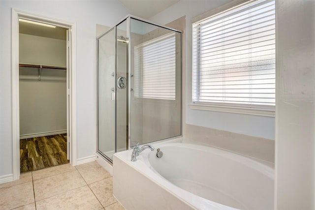 2144 Callahan Dr, Forney, TX 75126 - full bathroom with a stall shower, a walk in closet, a garden tub, tile patterned floors, and baseboards