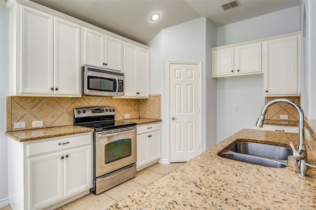2144 Callahan Dr, Forney, TX 75126 - kitchen with stainless steel appliances, a sink, light stone counters, white cabinets, and tasteful backsplash