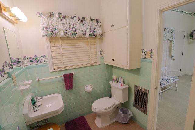 1000 S Harrison St, Mcgregor, TX 76657 - bathroom with a sink, toilet, a wainscoted wall, and tile walls