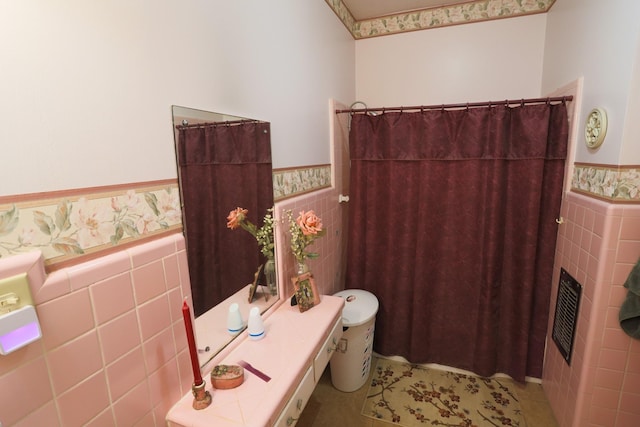 1000 S Harrison St, Mcgregor, TX 76657 - bathroom with tile walls, wainscoting, a shower with curtain, a fireplace, and tile patterned flooring