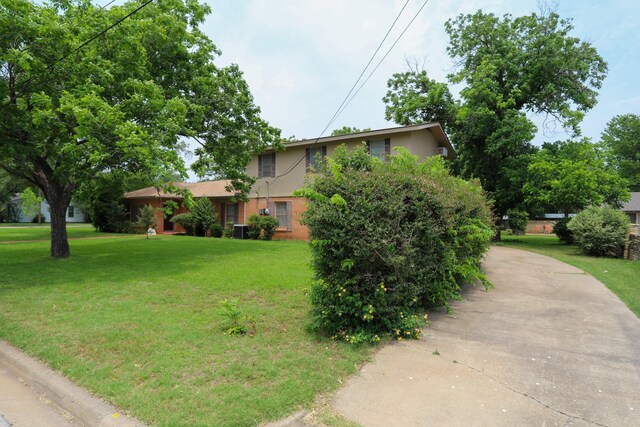 1000 S Harrison St, Mcgregor, TX 76657 - obstructed view of property with concrete driveway, stucco siding, and a front yard