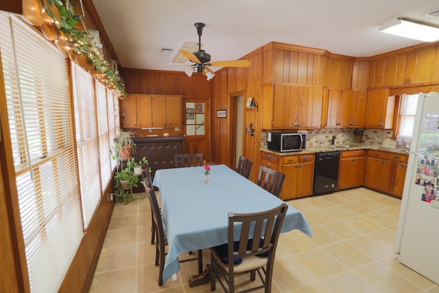 1000 S Harrison St, Mcgregor, TX 76657 - kitchen featuring black dishwasher, freestanding refrigerator, brown cabinetry, tasteful backsplash, and light countertops