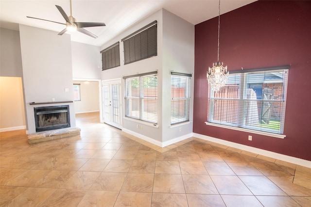 417 Red Coat Ln, Arlington, TX 76002 - unfurnished living room with a high ceiling, a chandelier, ceiling fan, baseboards, and tile patterned flooring