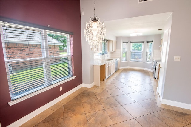 417 Red Coat Ln, Arlington, TX 76002 - kitchen with light countertops, baseboards, dishwasher, a chandelier, and light tile patterned flooring
