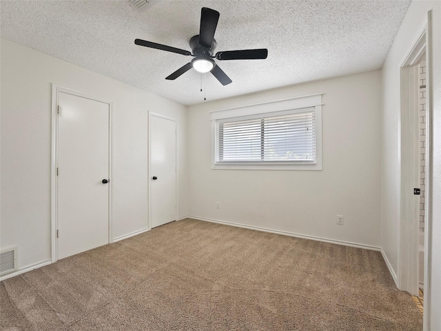 4509 Trowbridge Dr, Arlington, TX 76013 - unfurnished bedroom with carpet floors, a textured ceiling, a ceiling fan, and two closets
