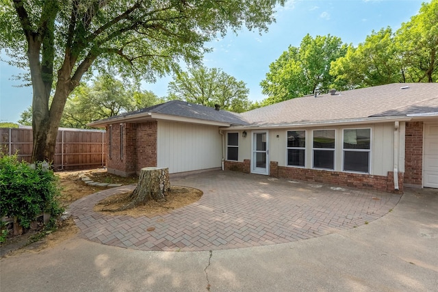 4509 Trowbridge Dr, Arlington, TX 76013 - back of property with brick siding, fence, a patio area, and roof with shingles