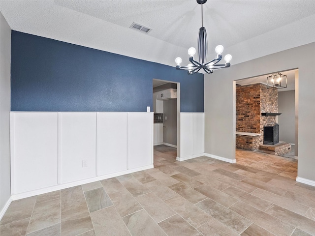 4509 Trowbridge Dr, Arlington, TX 76013 - unfurnished room featuring a chandelier, a fireplace, baseboards, and a textured ceiling