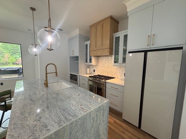 5073 Loper Cir, Streetman, TX 75859 - kitchen featuring freestanding refrigerator, a sink, tasteful backsplash, wood finished floors, and an island with sink