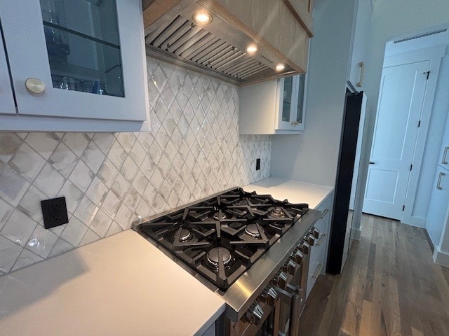 5073 Loper Cir, Streetman, TX 75859 - kitchen featuring custom range hood, light countertops, glass insert cabinets, wood finished floors, and refrigerator