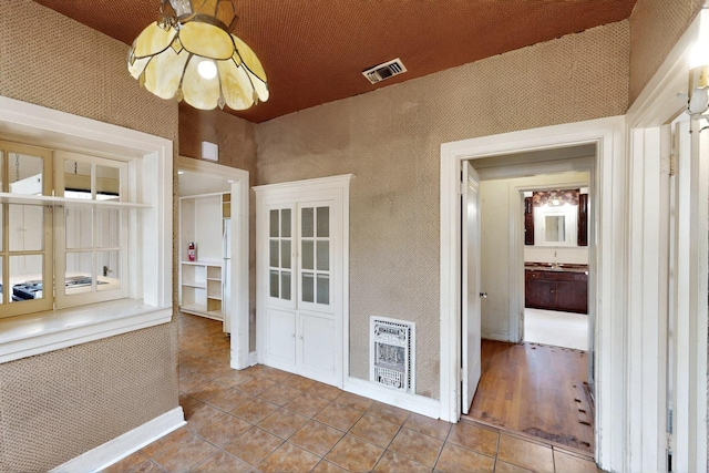 1022 N Edgefield Ave, Dallas, TX 75208 - unfurnished sunroom featuring heating unit and a chandelier