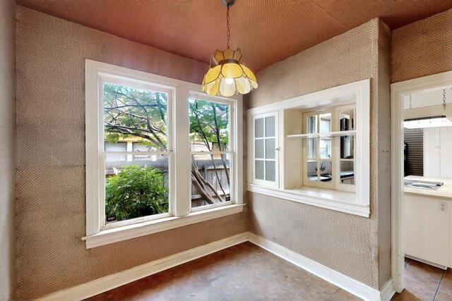 1022 N Edgefield Ave, Dallas, TX 75208 - unfurnished dining area with baseboards, a chandelier, and tile patterned flooring