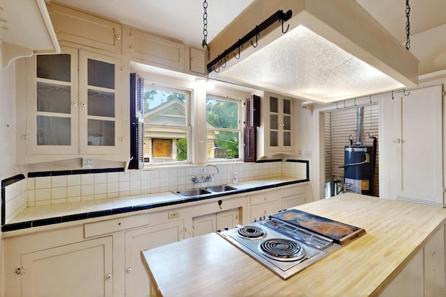 1022 N Edgefield Ave, Dallas, TX 75208 - kitchen featuring a sink, water heater, tasteful backsplash, and stovetop with downdraft