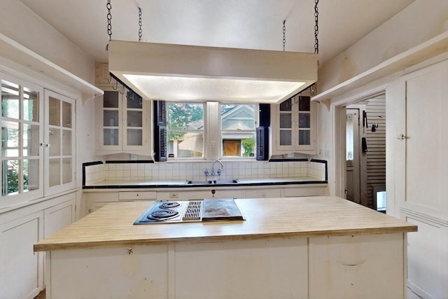 1022 N Edgefield Ave, Dallas, TX 75208 - kitchen featuring decorative backsplash, a center island, and glass insert cabinets