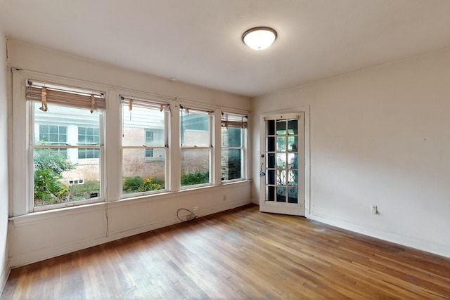 1022 N Edgefield Ave, Dallas, TX 75208 - empty room featuring wood finished floors, baseboards, and healthy amount of natural light