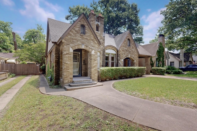 1022 N Edgefield Ave, Dallas, TX 75208 - tudor house with brick siding, a chimney, roof with shingles, and stone siding