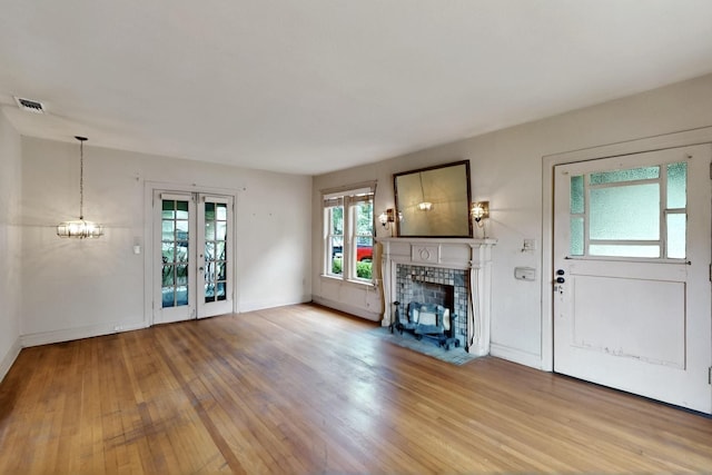 1022 N Edgefield Ave, Dallas, TX 75208 - unfurnished living room with a fireplace with flush hearth, wood finished floors, baseboards, and a chandelier