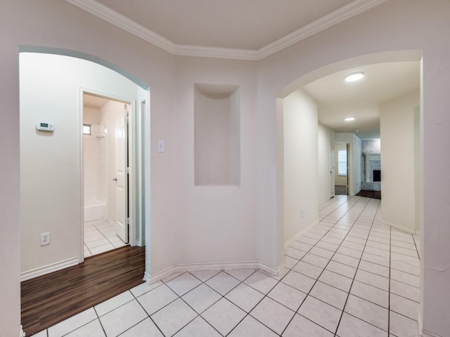 712 Hardwood Dr, Mckinney, TX 75069 - hallway featuring light tile patterned floors, arched walkways, ornamental molding, and baseboards