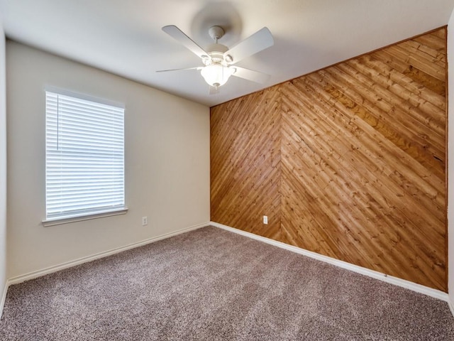 712 Hardwood Dr, Mckinney, TX 75069 - unfurnished room with wood walls, healthy amount of natural light, a ceiling fan, carpet flooring, and baseboards