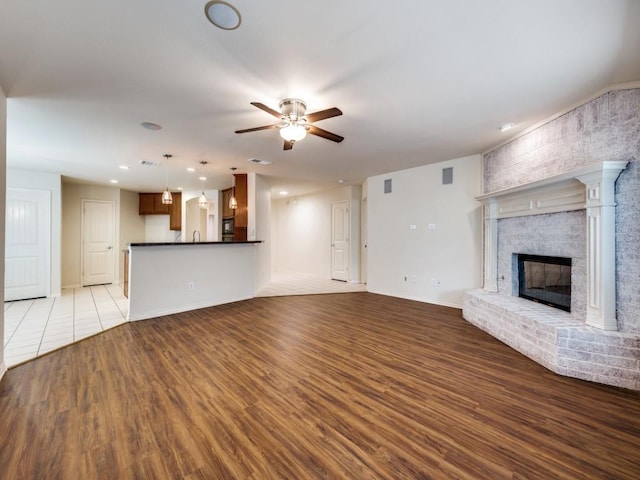 712 Hardwood Dr, Mckinney, TX 75069 - unfurnished living room with a ceiling fan, wood finished floors, a fireplace, recessed lighting, and baseboards
