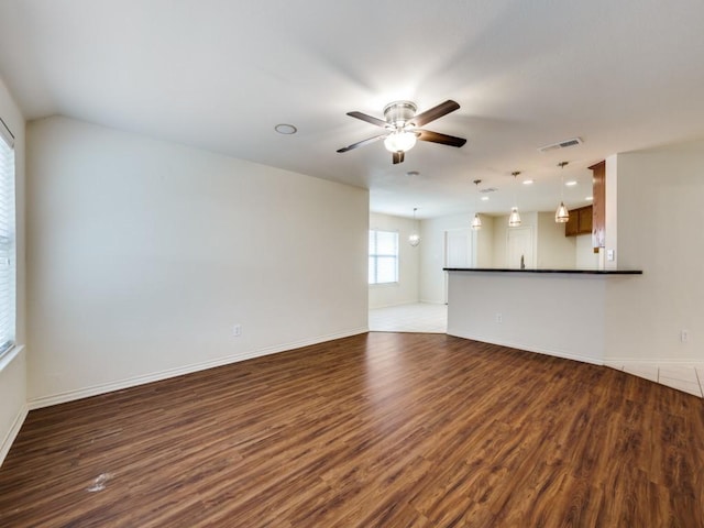 712 Hardwood Dr, Mckinney, TX 75069 - unfurnished living room featuring dark wood-type flooring, a ceiling fan, and baseboards