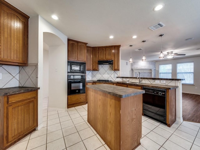 712 Hardwood Dr, Mckinney, TX 75069 - kitchen with black appliances, dark countertops, a peninsula, arched walkways, and a center island