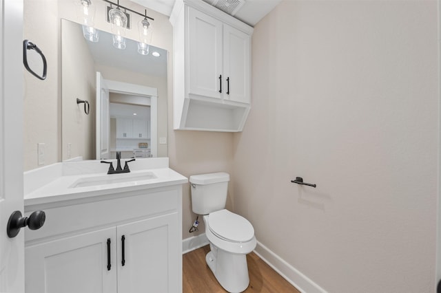 6701 Fish Pond Rd, Waco, TX 76710 - bathroom with toilet, wood finished floors, vanity, and baseboards
