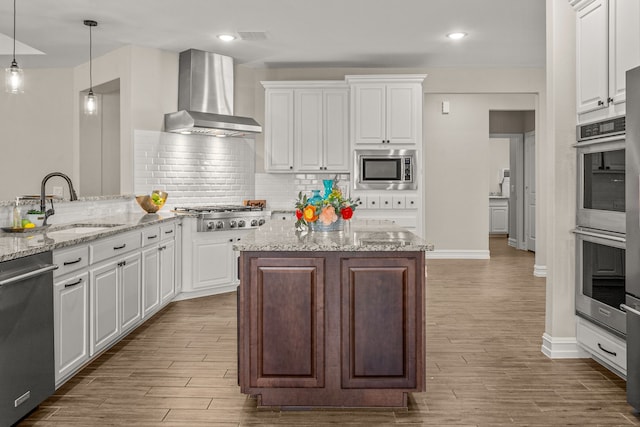 712 Freedom Ln, Little Elm, TX 76227 - kitchen featuring wall chimney exhaust hood, stainless steel appliances, a sink, wood finished floors, and recessed lighting