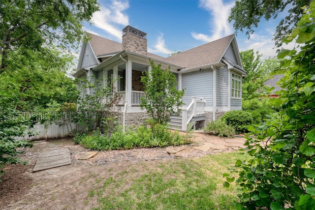 812 Baker St, Mckinney, TX 75069 - view of side of home featuring roof with shingles, a porch, and a chimney